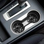 A pair of round black marble patterned ceramic stone car coasters with a cork base, designed to fit vehicle cupholders.