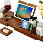 Kiasthome expandable teak wood bathtub caddy tray in dark natural teak, holding a book, wine glass, and soap.