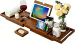 Kiasthome expandable teak wood bathtub caddy tray in dark natural teak, holding a book, wine glass, and soap.