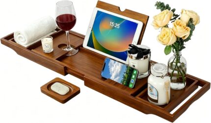 Kiasthome expandable teak wood bathtub caddy tray in dark natural teak, holding a book, wine glass, and soap.