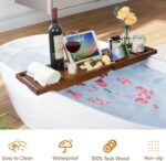 Kiasthome expandable teak wood bathtub caddy tray in dark natural teak, holding a book, wine glass, and soap.