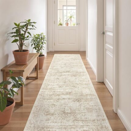 A beige/ivory Restydon 2x8 runner rug with a subtle pattern, laid out on a floor in an indoor setting.