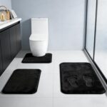 Three-piece RUN HELIX black memory foam bath rug set on a tile floor, showing large, small, and U-shape mats.