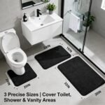 Three-piece RUN HELIX black memory foam bath rug set on a tile floor, showing large, small, and U-shape mats.