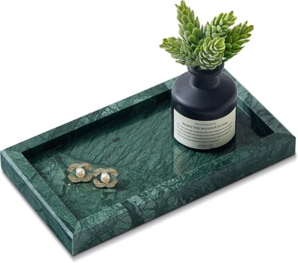 A rectangular green marble vanity tray by Sumlus, holding a small perfume bottle and a few pieces of jewelry.