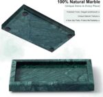 A rectangular green marble vanity tray by Sumlus, holding a small perfume bottle and a few pieces of jewelry.