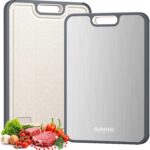 A sleek, silver rectangular Sumzzz titanium cutting board with a juice groove and garlic grinding area, shown on a kitchen co