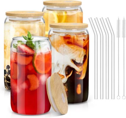 Four clear 16 oz sungwoo glass cups with bamboo lids and reusable straws, arranged neatly on a surface.
