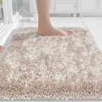 A rectangular Yimobra Khaki Chenille Bath Mat, thick and fluffy, placed on a light-colored bathroom floor.
