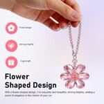 A vibrant Zigeiya pink crystal 3D flower charm hanging, reflecting colorful light against a soft background.
